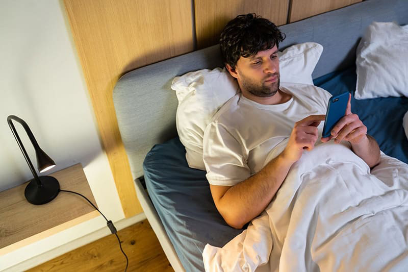 Xem điện thoại trên giường gần giờ đi ngủ khiến bạn khó vào giấc ngủ hơn